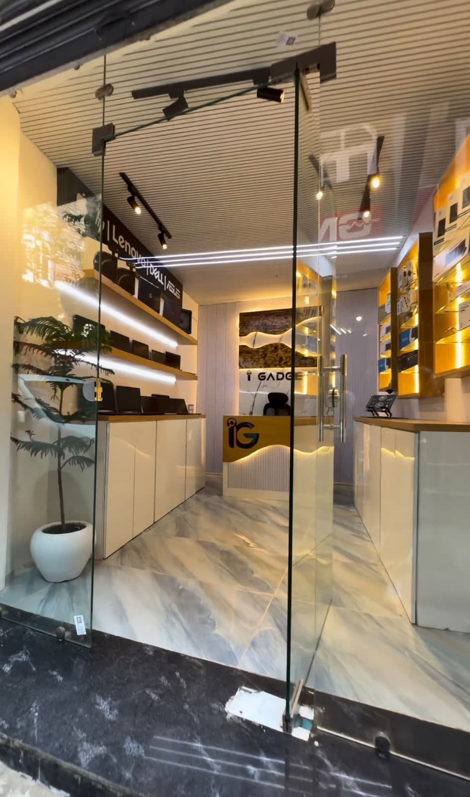 Inside the iGadget shop: laptop shelves, accessories wall and the reception desk