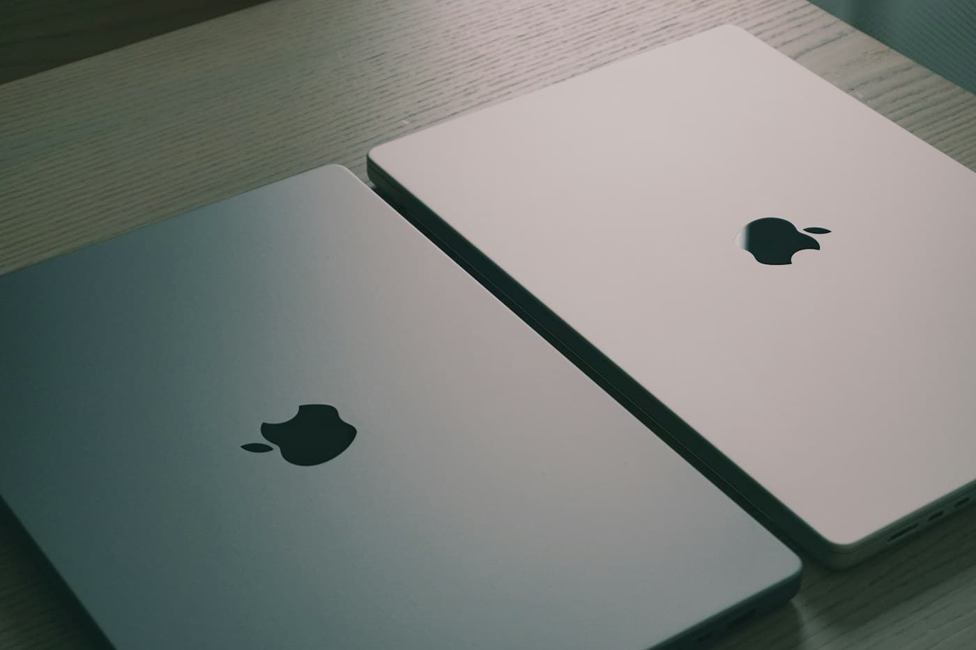 Two laptops side by side on a wooden table